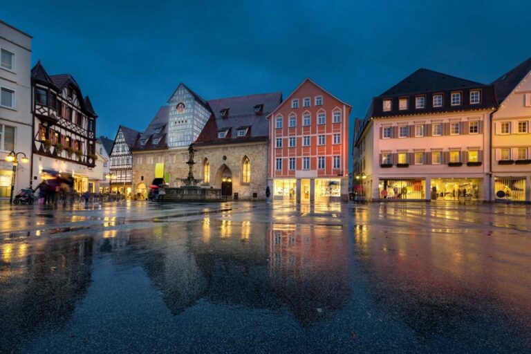 Historische Altstadt bei Nacht, beleuchtete Fassaden.