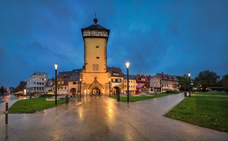 Historischer Turm bei Abenddämmerung in einer Stadtansicht