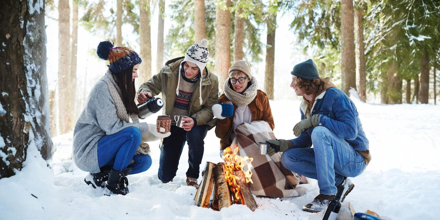 Gruppe am Lagerfeuer im verschneiten Wald